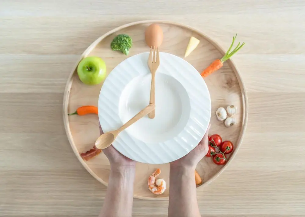 お皿の上の野菜とスプーンとフォークでできた時計
