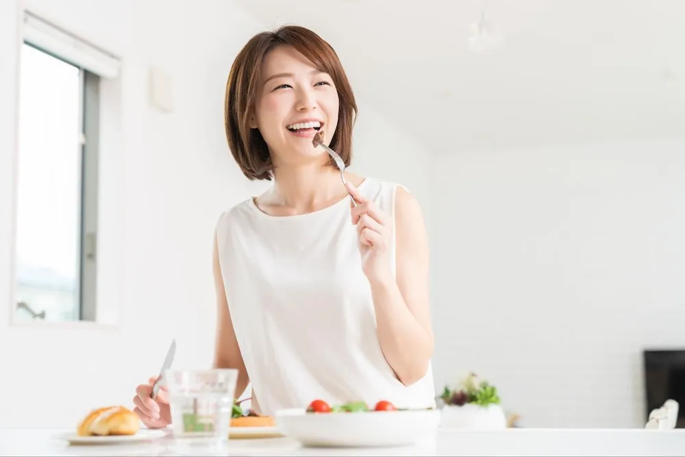 食事を摂る笑顔の女性