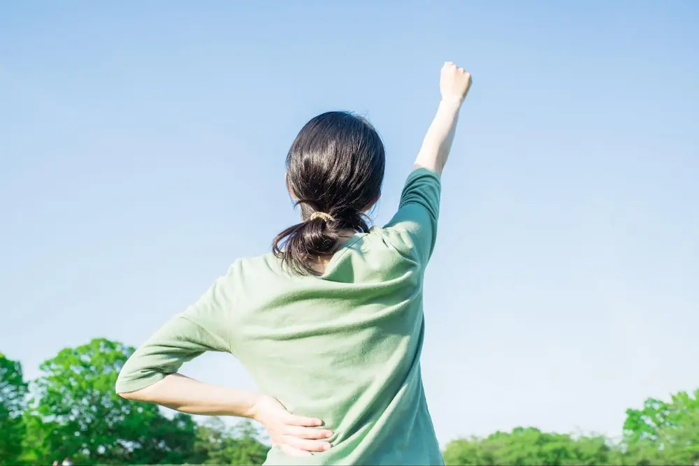 空に向かって拳をあげる女性